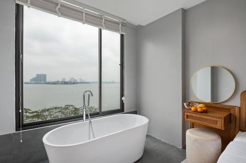 a bath tub in a bathroom with a large window at Lakeview Residence Hotel in Hanoi