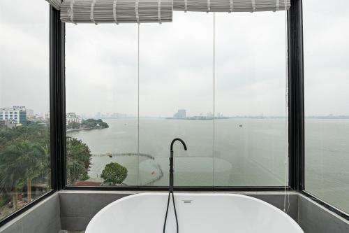 a bath tub in front of a large window at Lakeview Residence Hotel in Hanoi