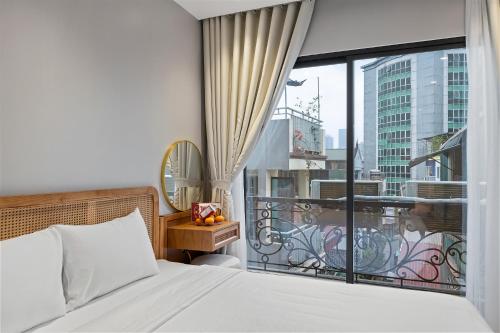a bedroom with a bed and a large window at Lakeview Residence Hotel in Hanoi