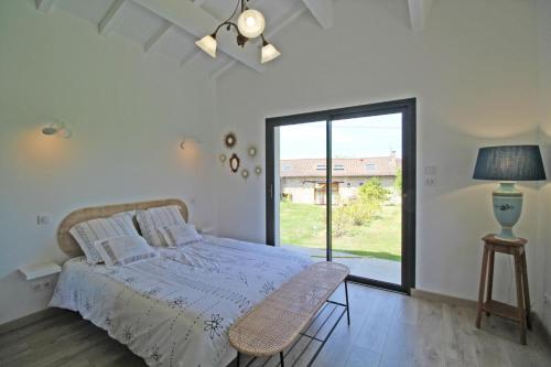 - une chambre avec un lit et une grande fenêtre dans l'établissement Puymoroux, à Saint-Mathieu