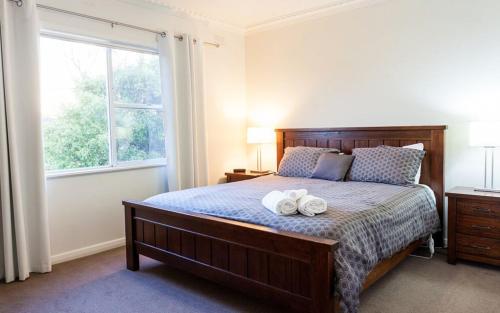 a bedroom with a bed with two towels on it at Point Lonsdale Holiday Apartments in Queenscliff