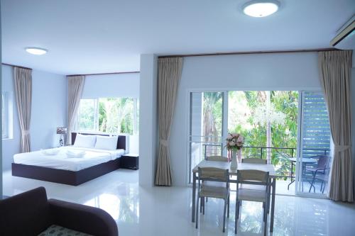 1 dormitorio con 1 cama, mesa y sillas en โรงแรม ปารวี บูทีค เชียงราย (Parawee Boutique Hotel) en Chiang Rai