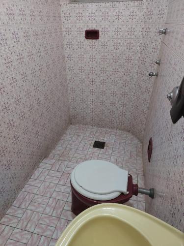 a bathroom with a toilet and a sink in it at Hotel Flamingo in Santos