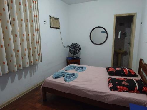 a bedroom with a bed and a mirror and a fan at Hotel Flamingo in Santos