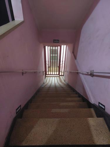 a hallway with stairs in an empty building at Hotel Flamingo in Santos
