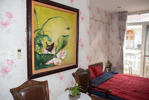 a bedroom with a bed and a painting on the wall at Small Room Close to TSN Airport Everspring house in Ho Chi Minh City