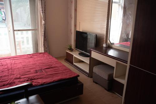 a bedroom with a red bed and a television at Small Room Close to TSN Airport Everspring house in Ho Chi Minh City