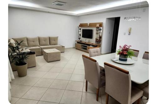 sala de estar con mesa y sofá en Quarto no Apartamento Neves, en Araxá
