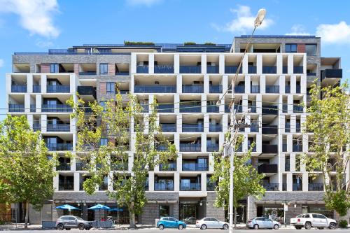 an apartment building with cars parked in front of it at COMPLETE HOST Park View St Kilda in Melbourne