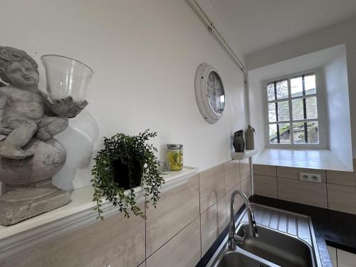 a kitchen with a sink and a statue next to a window at Gîte Souvigny, 7 pièces, 13 personnes - FR-1-489-509 in Souvigny