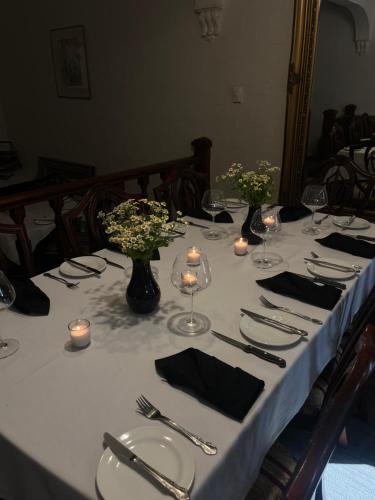 een tafel met een witte tafeldoek met kaarsen en bloemen bij Victoria House Motor Inn in Croydon