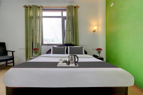 a bedroom with a large bed in a green room at Capital O Yasmin Resort in Baghwānpur