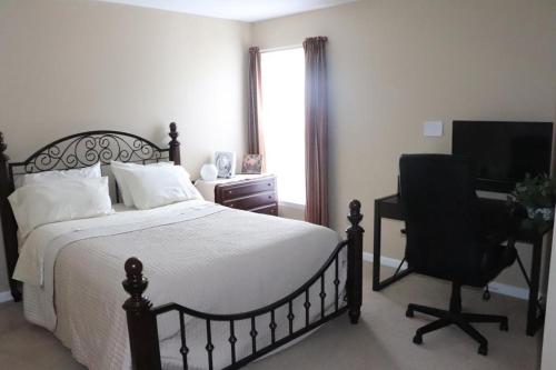 a bedroom with a bed and a desk and a computer at Safari Rooms in Concord