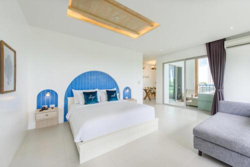 a bedroom with a large bed and a couch at Costa Village Jacuzzi Bangsaray in Bang Sare