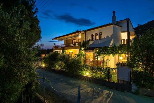 a white house with lights on a street at night at Tsamakdas House in Toroni