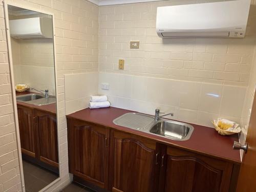 a bathroom with a sink and a mirror at City Centre Motel Kempsey in Kempsey