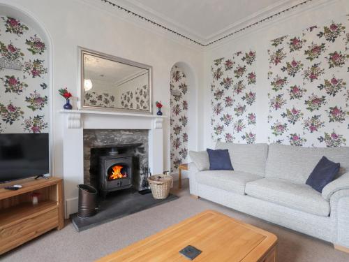 a living room with a couch and a fireplace at Arden House in Kingussie