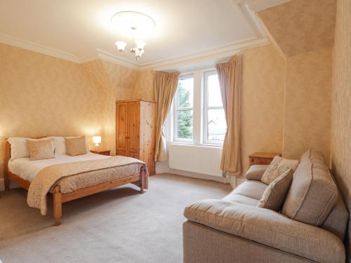 - une chambre avec un lit, un canapé et une fenêtre dans l'établissement Arden House, à Kingussie