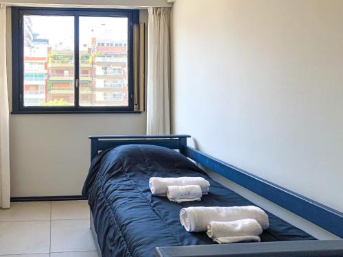 2 toallas en una cama en una habitación con ventana en Turismo Aparts Belgrano en Buenos Aires