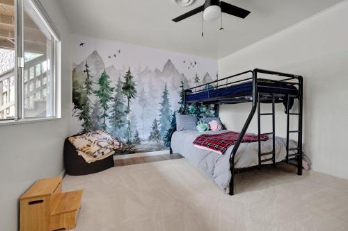 a bedroom with a bunk bed with a mural of trees at Álaínn Cabin in the trees in Twain Harte