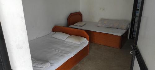 2 Einzelbetten in einem kleinen Zimmer mit gedankenlosem, gedankenlosem, gedankenlosem, gedankenlosem in der Unterkunft Lumbini Village Garden Lodge in Rummindei