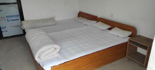 1 cama grande con sábanas blancas y almohadas. en Lumbini Village Garden Lodge, en Rummindei