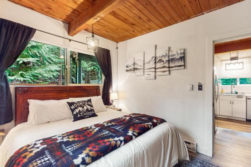 1 dormitorio con cama y ventana grande en MACS Cushman Cabin, en Hoodsport
