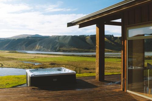a hot tub sitting on a deck next to a building at Montrose Estate in Mount Hutt