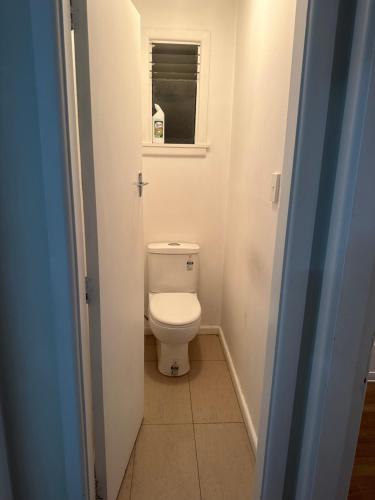 a bathroom with a toilet and a window at One bedroom entire unit in Christchurch