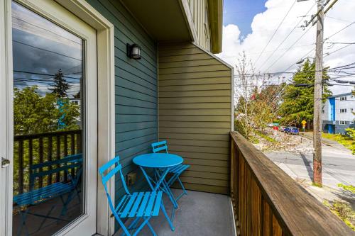 a porch with two blue chairs and a table at Stylish North Seattle Townhouse- Dual Master Suites in Seattle