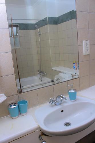 a bathroom with a sink and a mirror at Cozy stay in Gaborone