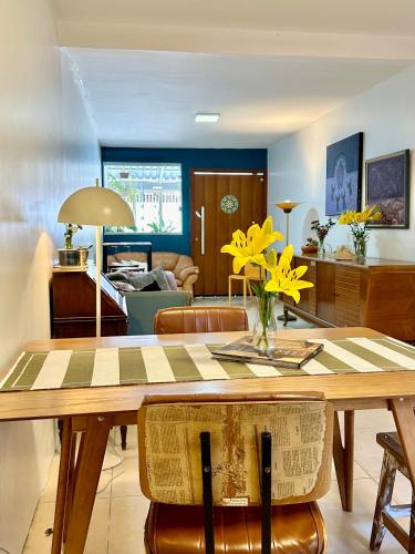 a dining room with a table with yellow flowers on it at Casa Lumen in Núcleo Bandeirante