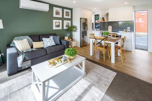 a living room with a couch and a table at Lovely in Linwood: 2BR Beauty in Christchurch