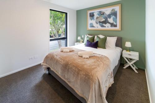 a bedroom with a large bed and a window at Lovely in Linwood: 2BR Beauty in Christchurch