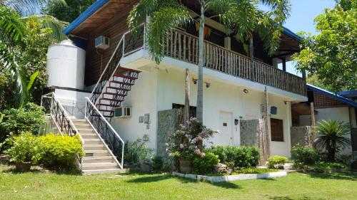 a house with stairs and plants in front of it at La Vida Hostel Samal Island in Samal