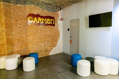 Pokój z białymi krzesłami i ceglaną ścianą w obiekcie Hostal Carmen-Gran Vía w Madrycie