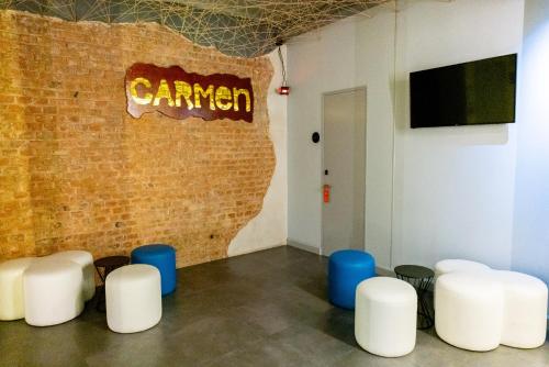 a room with white chairs and a brick wall at Hostal Carmen-Gran Vía in Madrid