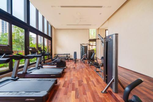 a gym with a row of treadmills and ellipticals at Taihua Wutong Apartment in Bao'an