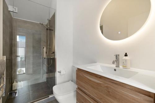 W łazience znajduje się umywalka, toaleta i lustro. w obiekcie Woolshed retreat - Queenstown w mieście Queenstown
