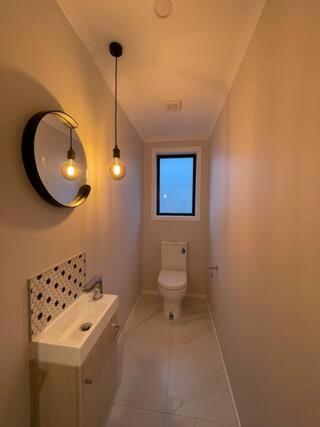 a bathroom with a toilet and a sink and a mirror at Quiet and private room for stay in Wellington