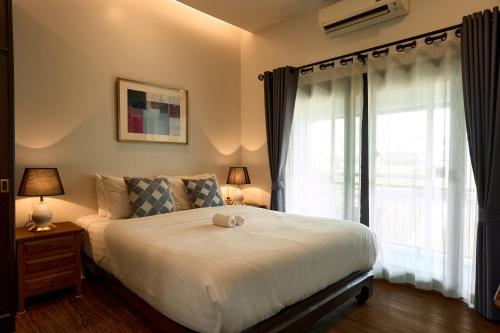 Un dormitorio con una cama con un osito de peluche. en Teera villa chiang mai ทีร่าวิลล่าเชียงใหม่ en Chiang Mai