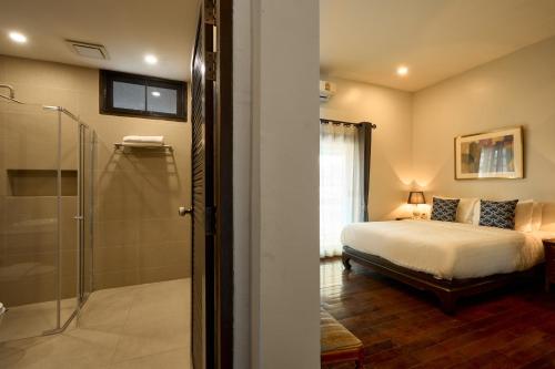 1 dormitorio con 1 cama y ducha acristalada en Teera villa chiang mai ทีร่าวิลล่าเชียงใหม่ en Chiang Mai