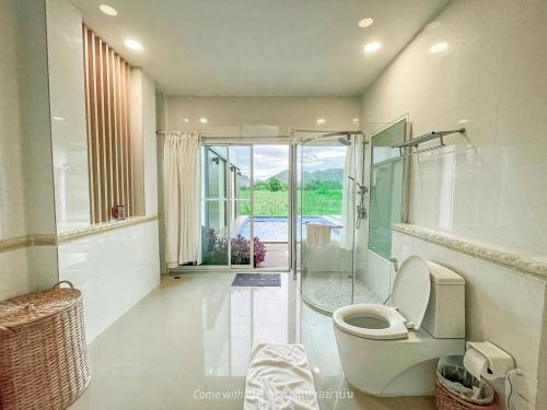 a bathroom with a toilet and a walk in shower at The Vista Pool Villa in Kanchanaburi