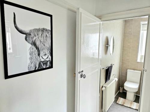 a bathroom with a picture of a cow on the wall at Charming 3-Bed Oasis-free parking in Glasgow
