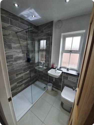 a bathroom with a shower and a toilet and a sink at Spacious 3-Bed Home in York Free Parking Sleeps 5 in York