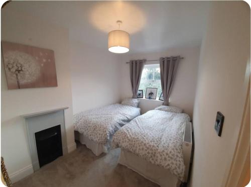 a bedroom with two beds and a fireplace at York huntington Holiday let in York