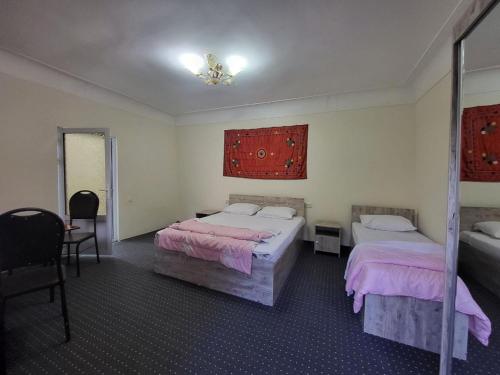 a bedroom with two beds and a mirror at Bobo Haydar Guest House in Bukhara