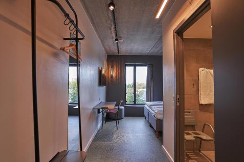 Zimmer mit einem Bett, einem Schreibtisch und einem Spiegel in der Unterkunft Zleep Hotel Zürich-Kloten in Kloten