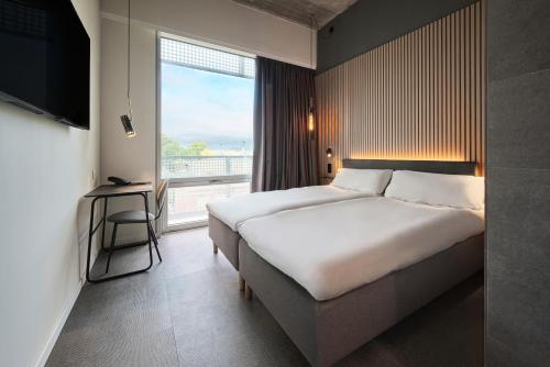 Zleep Hotel Zürich-Kloten في كلوتان: غرفة فندقية بسرير كبير ونافذة