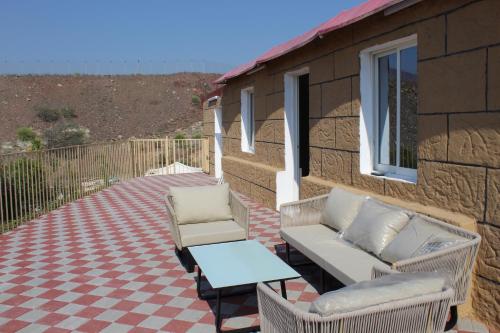 a patio with two chairs and a table and a couch at Hatta Hills in Al Ḩajarayn